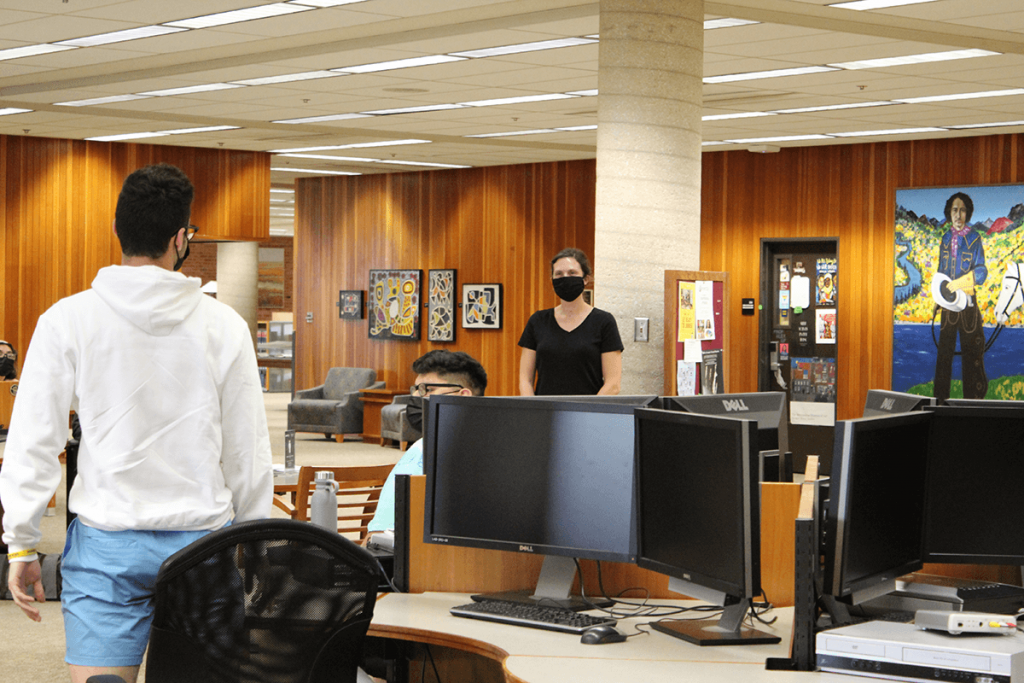 Librarian Anne Graf working with students in the Library Commons Area